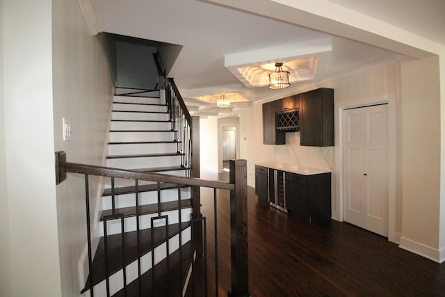 staircase featuring hardwood / wood-style floors, a tray ceiling, ornamental molding, and a notable chandelier