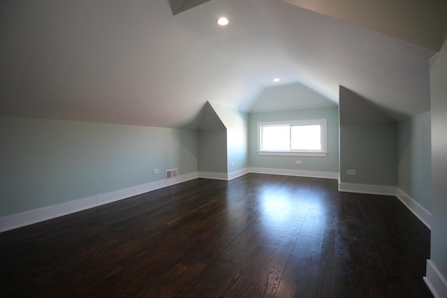 bonus room featuring dark wood-type flooring and lofted ceiling