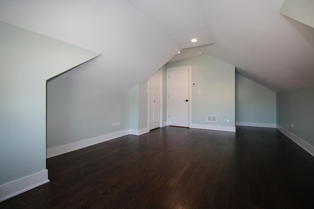 bonus room with lofted ceiling and dark hardwood / wood-style flooring