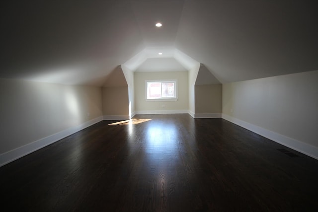 bonus room with vaulted ceiling and dark hardwood / wood-style flooring