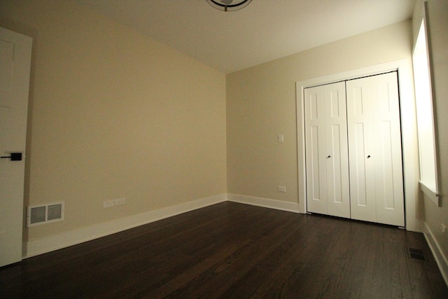 unfurnished bedroom featuring a closet and dark hardwood / wood-style floors