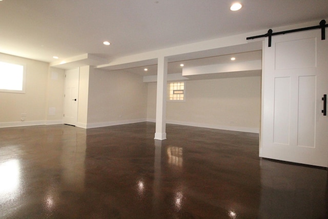 basement featuring a barn door and a healthy amount of sunlight