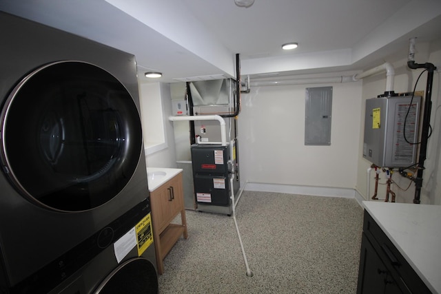 laundry area featuring electric panel, heating unit, stacked washer / dryer, water heater, and cabinets