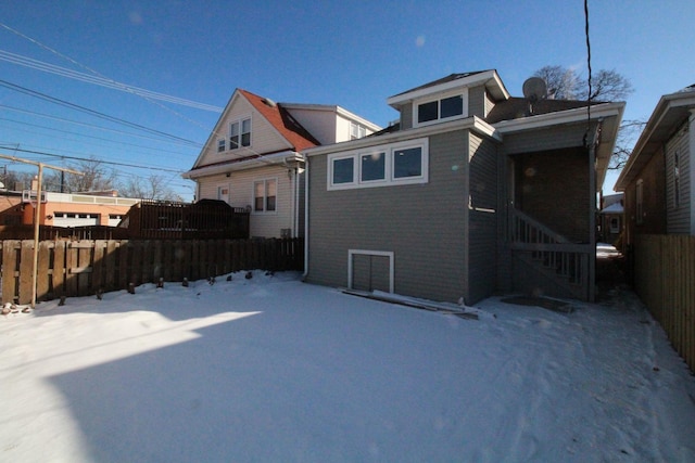 view of snow covered rear of property