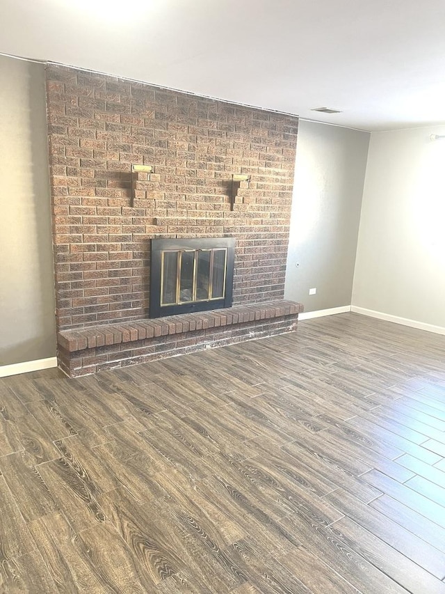 unfurnished living room with a fireplace and hardwood / wood-style flooring