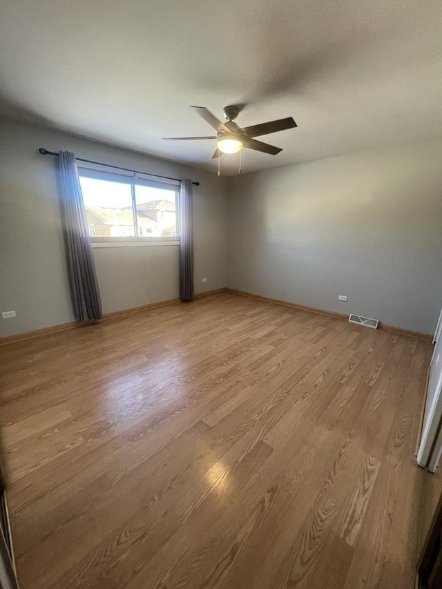 empty room featuring ceiling fan and light hardwood / wood-style flooring