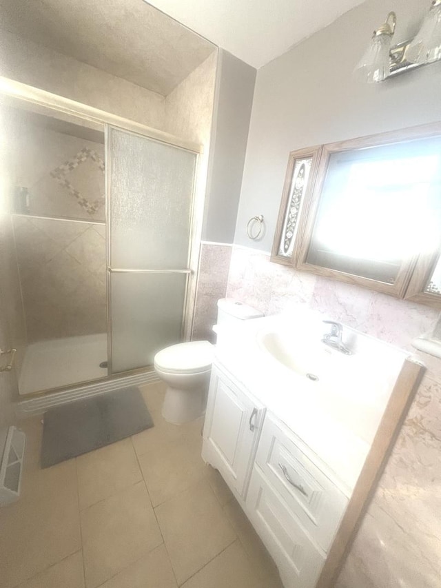 bathroom featuring toilet, tile walls, tile patterned floors, an enclosed shower, and vanity