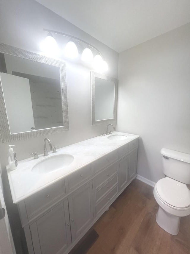 bathroom with toilet, vanity, and hardwood / wood-style flooring