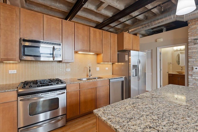 2545 S Dearborn St Unit 508, Chicago, IL 60616 - kitchen with appliances with stainless steel finishes, a sink, light wood-style flooring, backsplash, and light stone counters