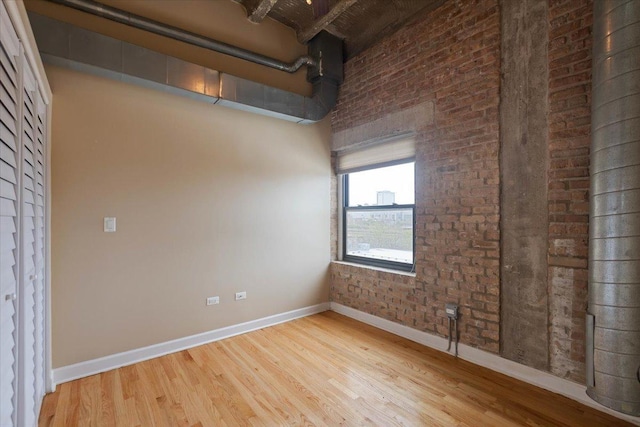 2545 S Dearborn St Unit 508, Chicago, IL 60616 - empty room with baseboards, wood finished floors, and brick wall