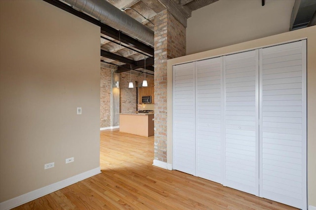 2545 S Dearborn St Unit 508, Chicago, IL 60616 - interior space with brick wall, light wood-style flooring, baseboards, and a high ceiling