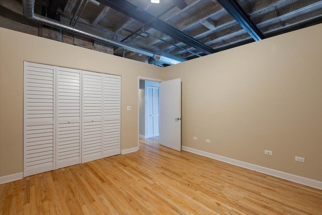 2545 S Dearborn St Unit 508, Chicago, IL 60616 - unfurnished bedroom with wood finished floors, baseboards, and a closet