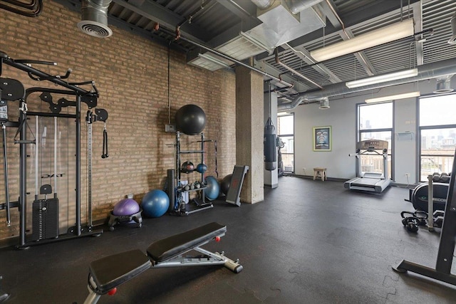 2545 S Dearborn St Unit 508, Chicago, IL 60616 - exercise room featuring brick wall, a towering ceiling, and water heater