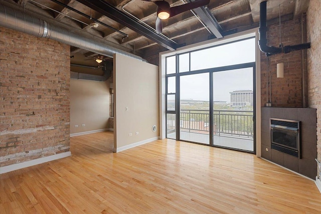 2545 S Dearborn St Unit 508, Chicago, IL 60616 - unfurnished living room featuring wood finished floors, baseboards, beamed ceiling, a glass covered fireplace, and wood ceiling