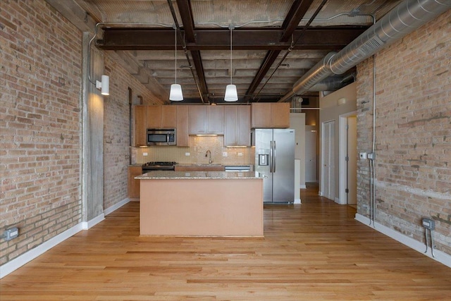 2545 S Dearborn St Unit 508, Chicago, IL 60616 - kitchen with appliances with stainless steel finishes, brick wall, a sink, light wood-type flooring, and baseboards