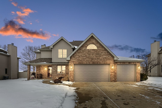 view of front of property with central AC unit and a garage