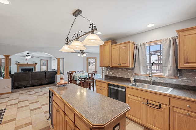 kitchen featuring a center island, black dishwasher, sink, backsplash, and hanging light fixtures