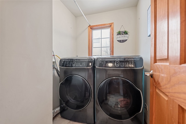 washroom with light tile patterned floors and washer and clothes dryer