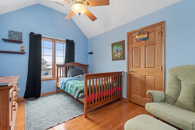 bedroom featuring light hardwood / wood-style floors, vaulted ceiling, and ceiling fan