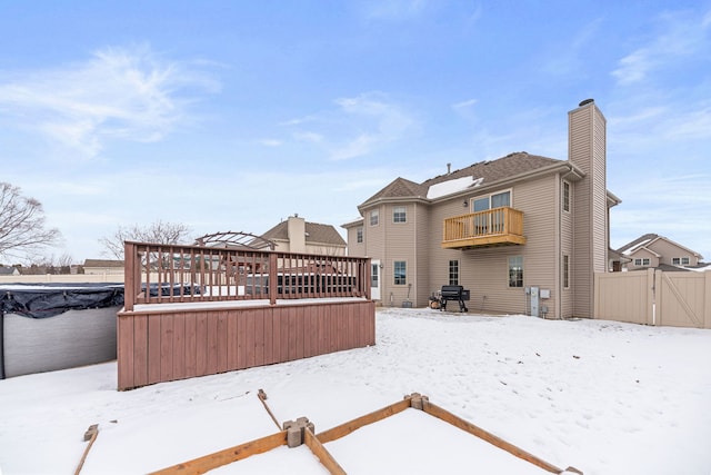 snow covered house with a deck and a balcony