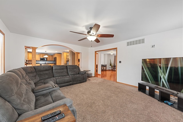 living room with ceiling fan and carpet