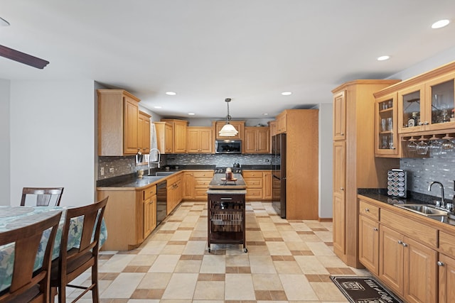 kitchen featuring sink, pendant lighting, black appliances, and a center island