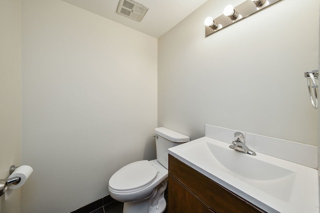 bathroom with tile patterned flooring, vanity, and toilet