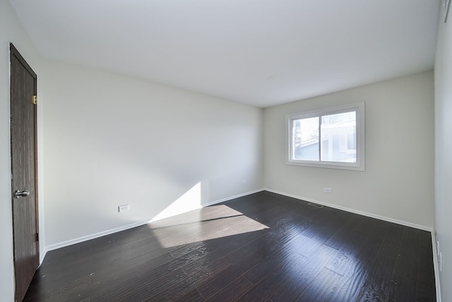 unfurnished room featuring dark wood-type flooring