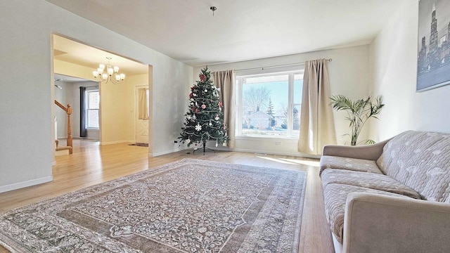 living room with hardwood / wood-style flooring, a chandelier, and a healthy amount of sunlight