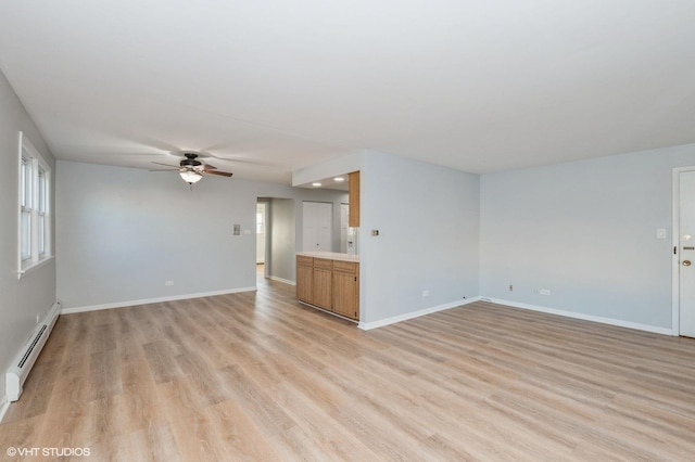 unfurnished living room featuring light hardwood / wood-style floors, a baseboard heating unit, and ceiling fan