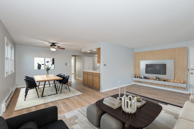 living room featuring ceiling fan, a baseboard heating unit, and light hardwood / wood-style flooring