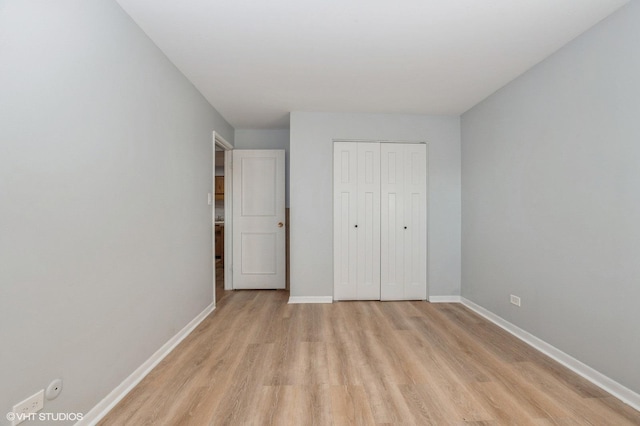 unfurnished bedroom with a closet and light wood-type flooring