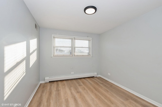 empty room with a baseboard heating unit and light wood-type flooring