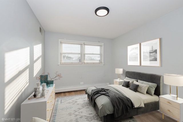 bedroom featuring baseboard heating and light wood-type flooring