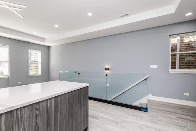 interior space featuring light hardwood / wood-style floors and a tray ceiling