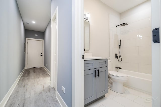 full bathroom with toilet, vanity, hardwood / wood-style flooring, and tiled shower / bath