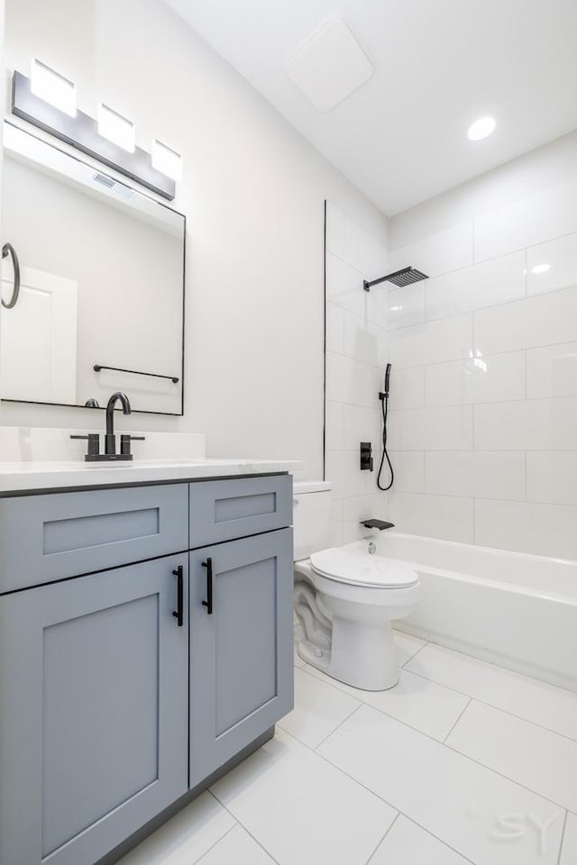 full bathroom with tile patterned flooring, toilet, vanity, and tiled shower / bath