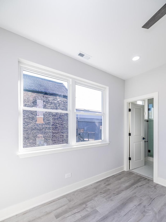 spare room with light wood-type flooring and ceiling fan