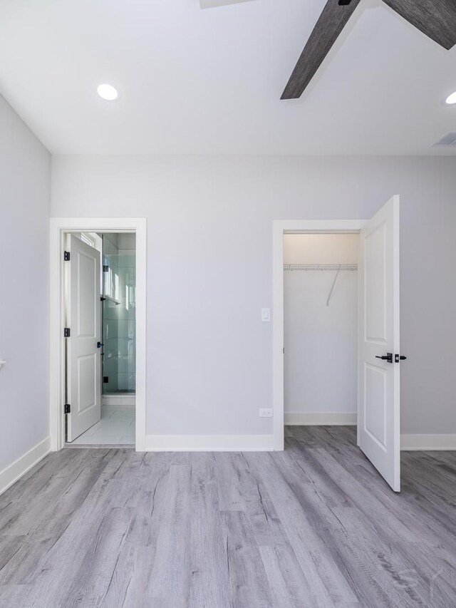 unfurnished bedroom featuring light hardwood / wood-style floors, ceiling fan, and ensuite bathroom