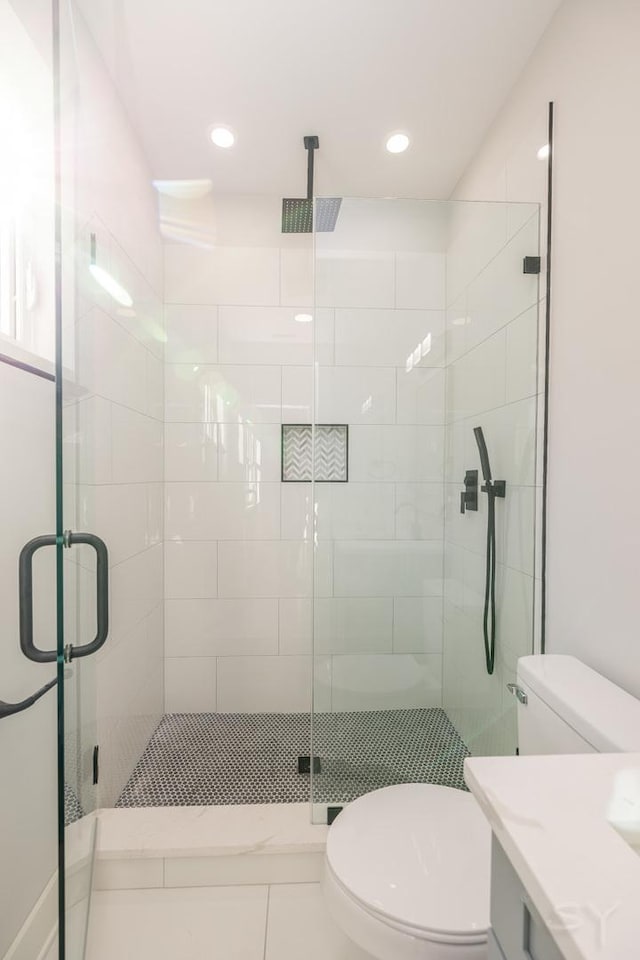 bathroom featuring vanity, tile patterned flooring, a shower with shower door, and toilet