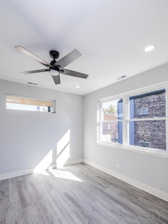 unfurnished room featuring ceiling fan, wood-type flooring, and plenty of natural light