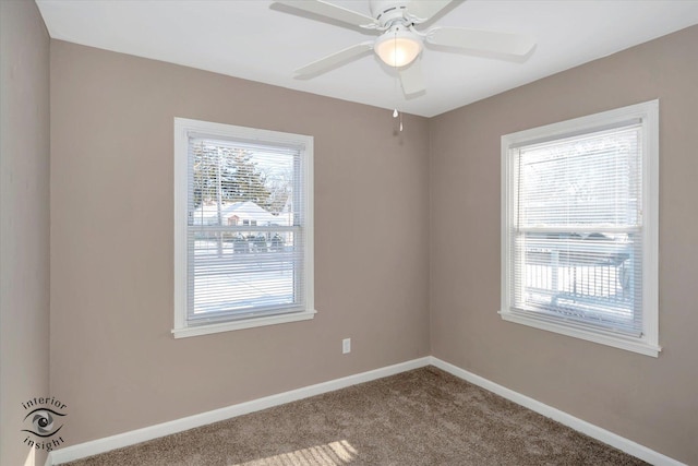 carpeted spare room featuring ceiling fan and a wealth of natural light