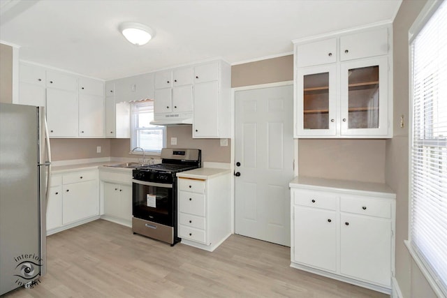 kitchen featuring appliances with stainless steel finishes, light hardwood / wood-style floors, white cabinets, and sink