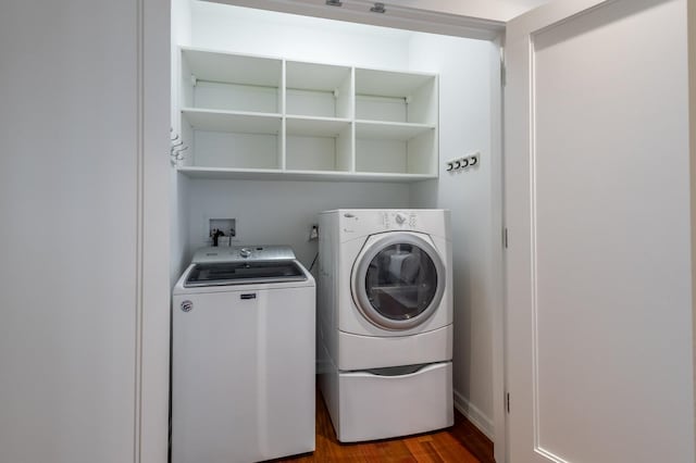 laundry room with washer and dryer and hardwood / wood-style flooring