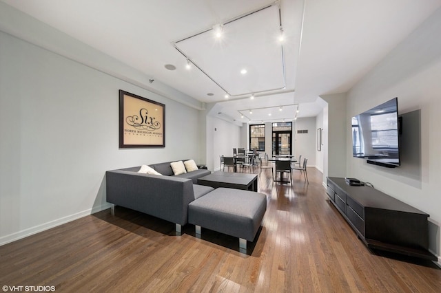 living room featuring rail lighting and hardwood / wood-style flooring