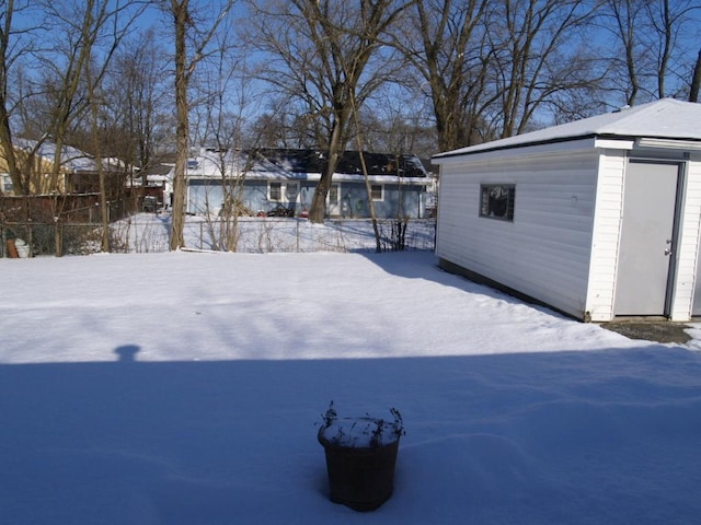 yard layered in snow with an outdoor structure