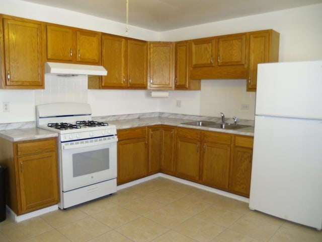 kitchen featuring white appliances, light tile patterned floors, and sink