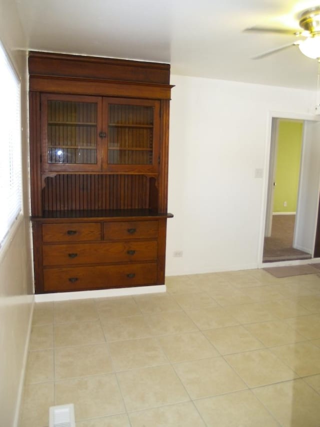 tiled empty room with ceiling fan