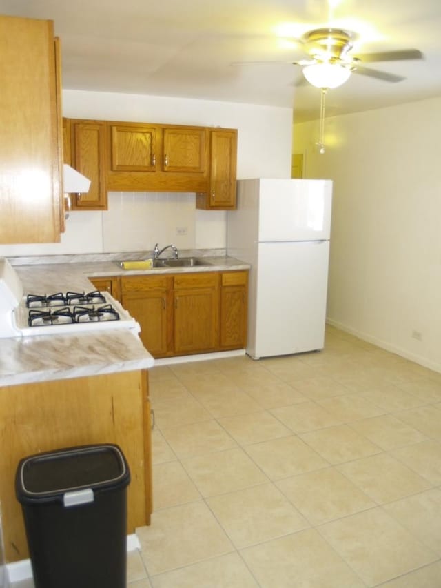 kitchen featuring sink, ceiling fan, white fridge, and stove