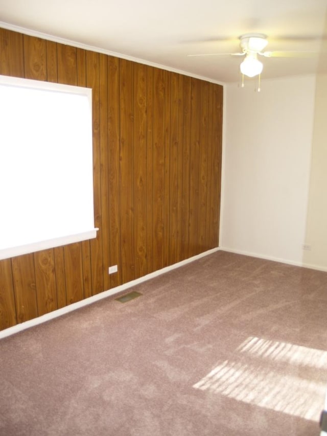 spare room featuring carpet floors, ceiling fan, and ornamental molding